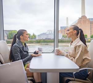Girls on a boat chatting , battersea power station background