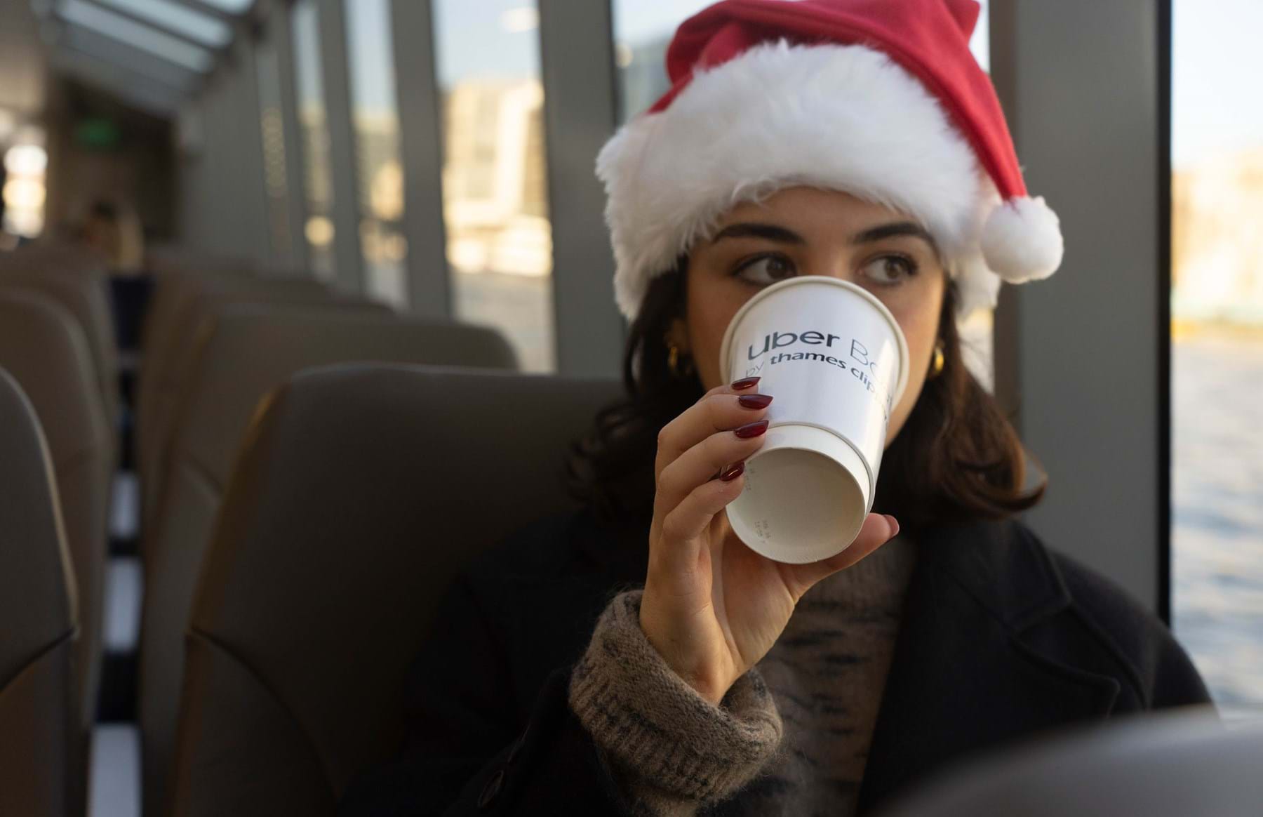 Girl with Christmas hat drinking hot drink